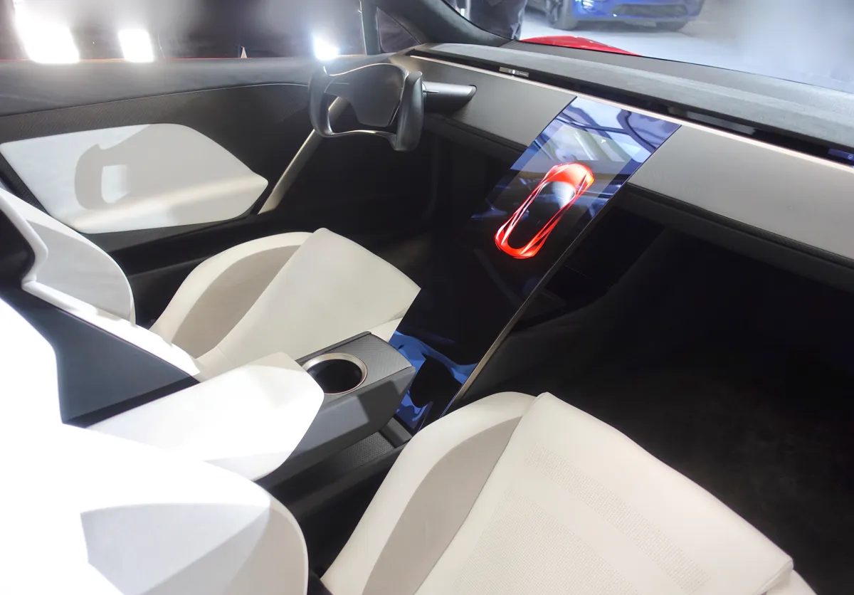 Intérieur du prototype de Tesla Roadster de 2017 avec sièges blancs, volant ouvert et écran central