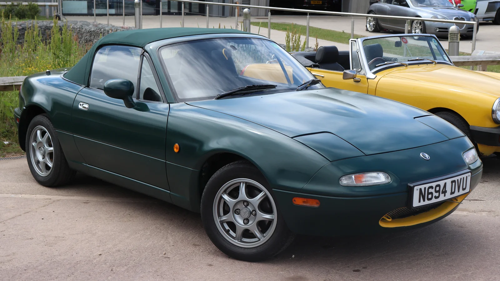 Mazda MX-5 de première génération de 1996, vert foncé, capote fermée, garée en extérieur